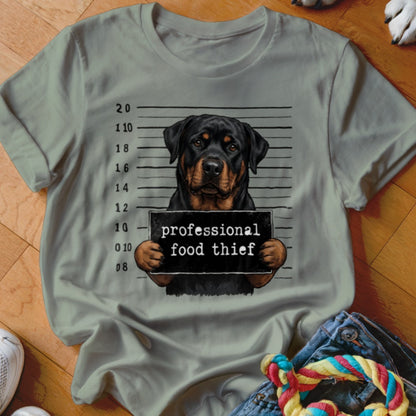 Rottweiler holding "professional food thief" sign against mugshot background.