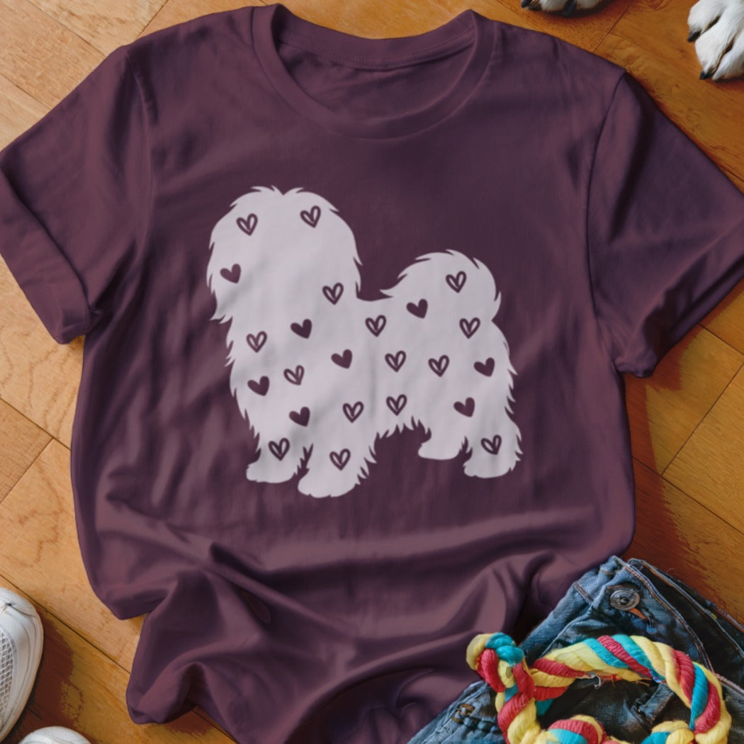White dog silhouette filled with small hearts on a maroon t-shirt.
