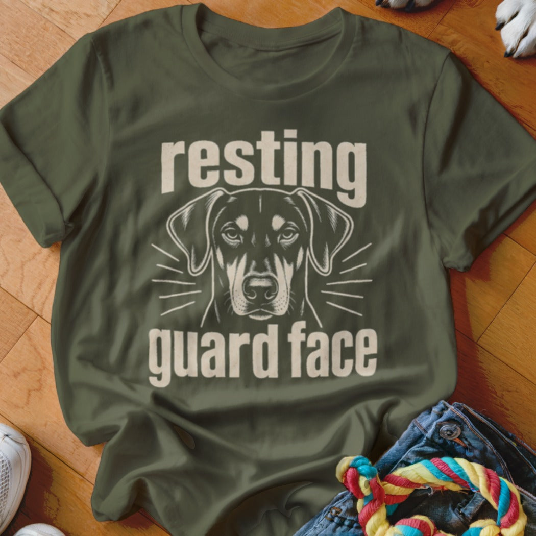 Olive green t-shirt with a dog graphic and text "resting guard face".