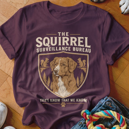 Maroon t-shirt featuring a dog graphic, crest, trees, and the text The Squirrel Surveillance Bureau.
