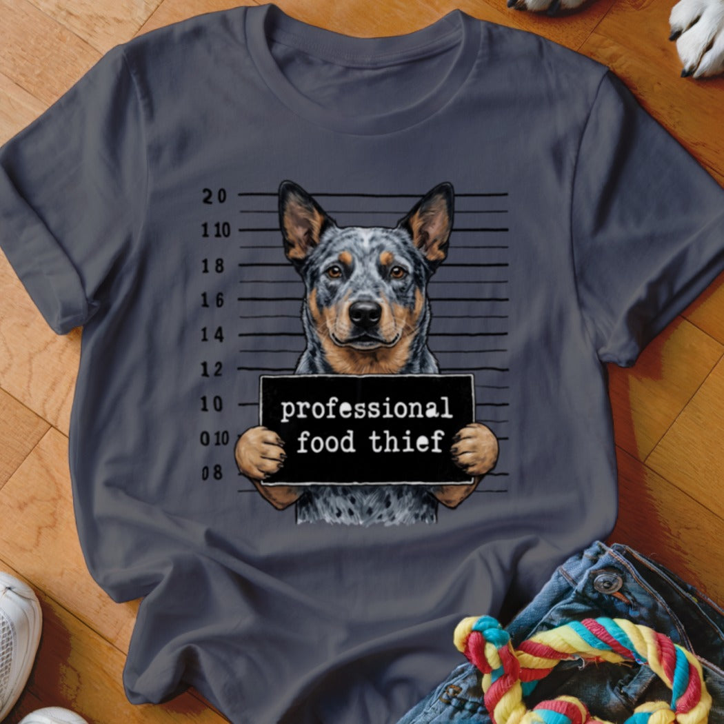 Dog in mugshot holding a sign that says "professional food thief".