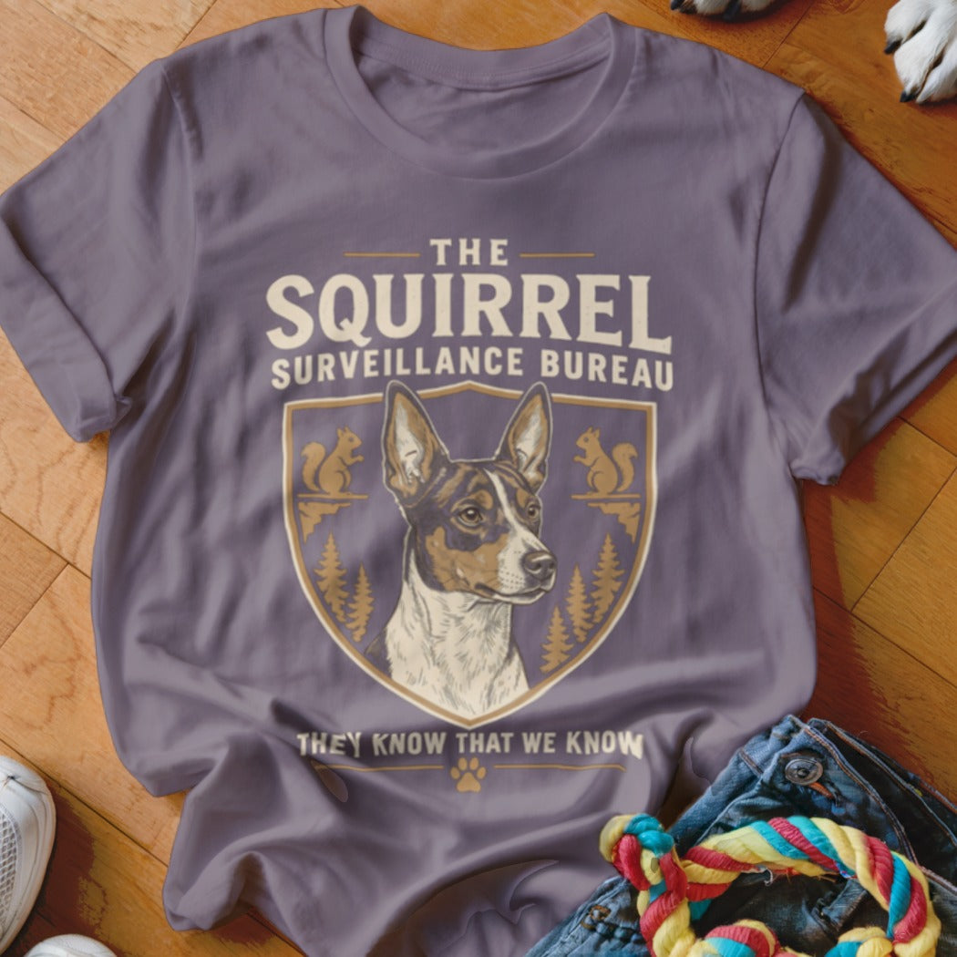 A purple t-shirt featuring a graphic crest of a dog and the text The Squirrel Surveillance Bureau.