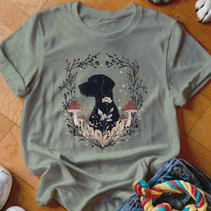 Muted green crewneck t-shirt featuring a graphic of a black dog surrounded by mushrooms, leaves, and a floral wreath.