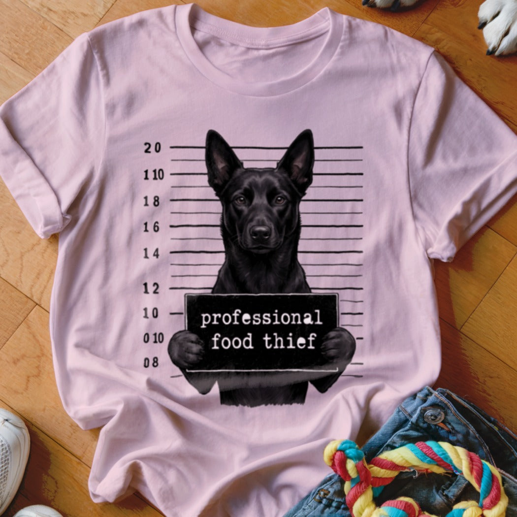 Black dog mugshot on light pink t-shirt with "professional food thief" sign.