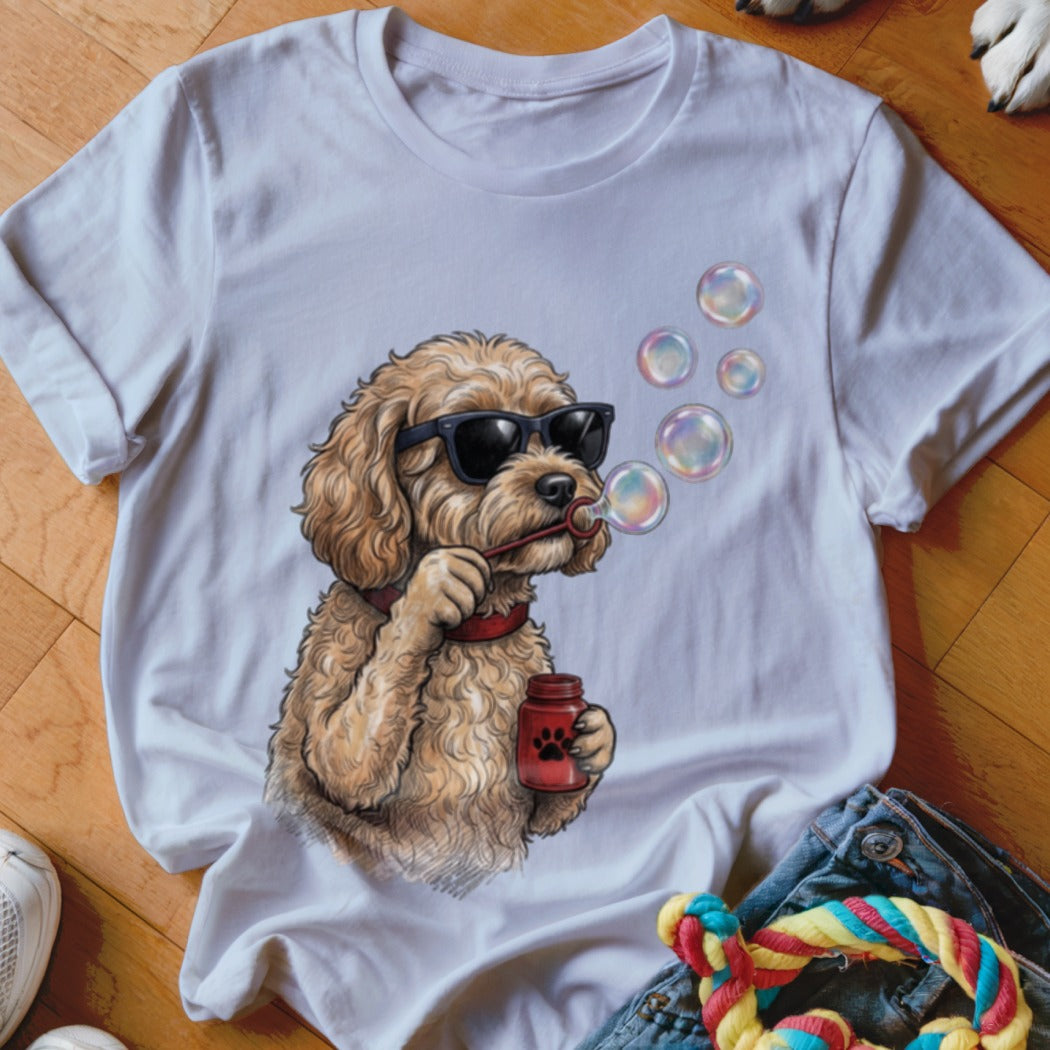 A white crewneck t-shirt featuring an illustrated golden doodle wearing sunglasses and blowing bubbles.