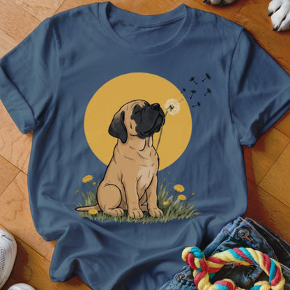 A blue t-shirt printed with a cartoon Mastiff puppy blowing dandelion seeds against a yellow sun.