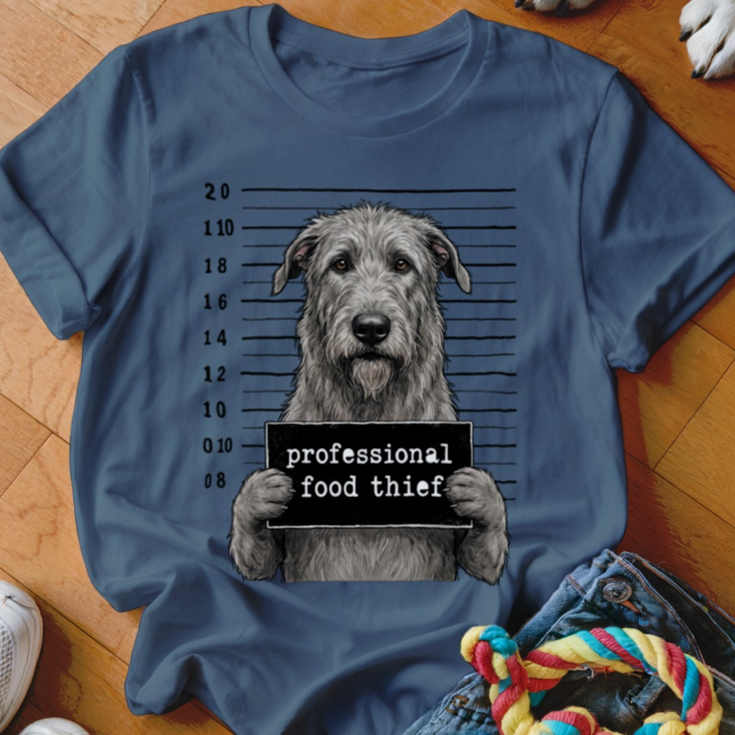 Irish Wolfhound mugshot with "professional food thief" sign on a blue t-shirt.