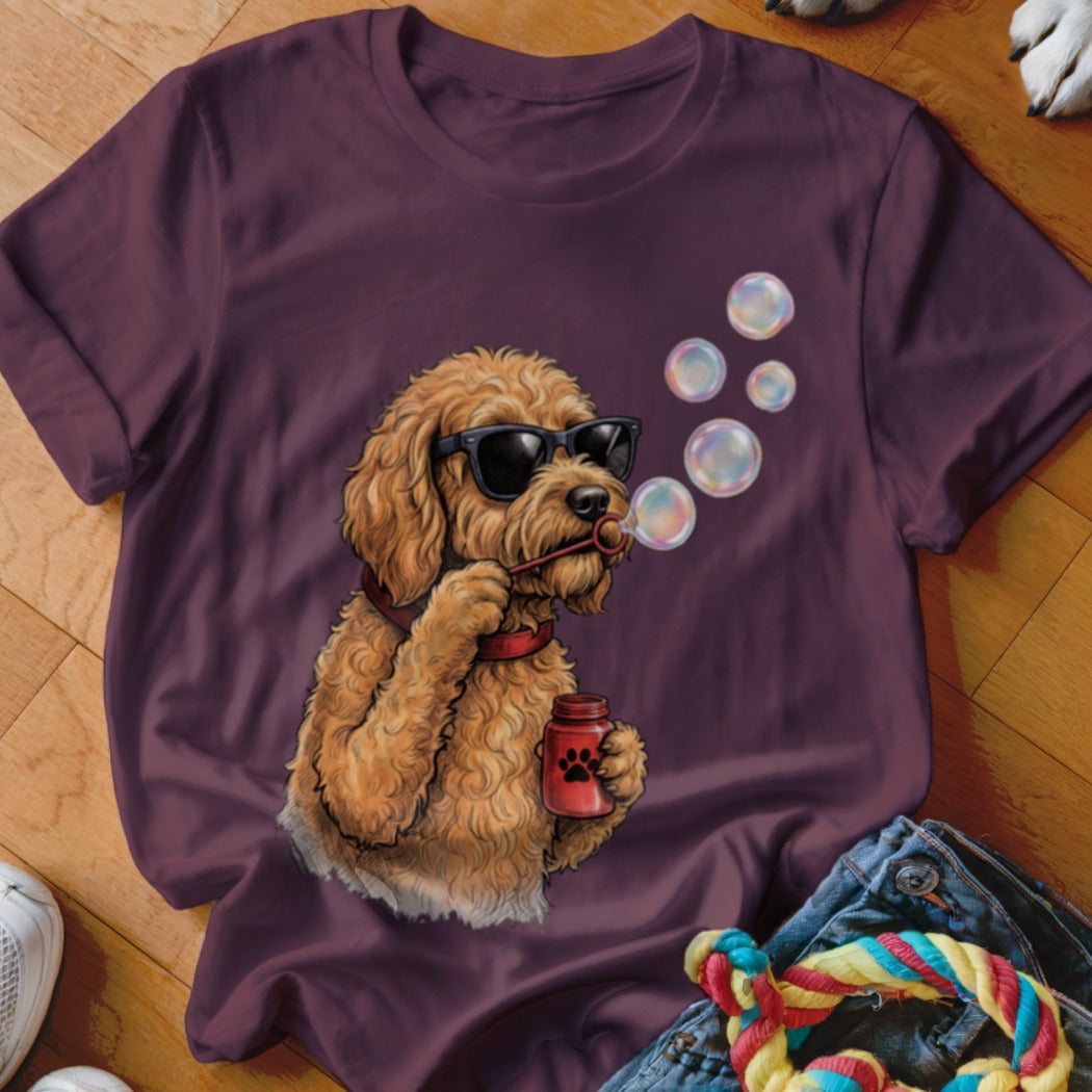 Maroon t-shirt featuring a graphic of a curly-haired dog wearing sunglasses and blowing bubbles.