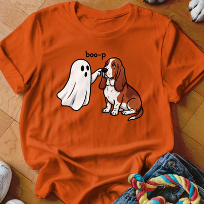Orange t-shirt with cartoon ghost booping a sad-faced Basset Hound.