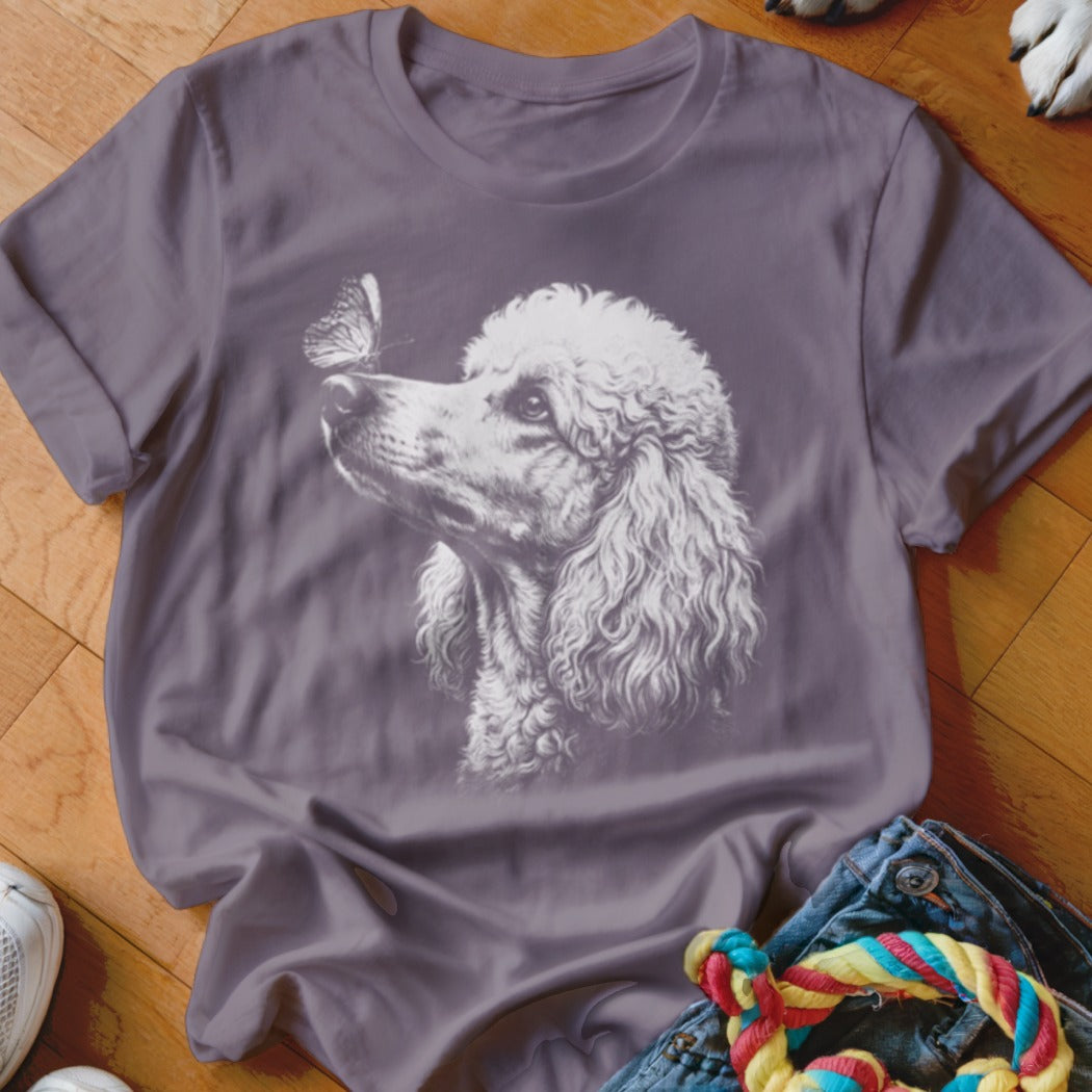 A purple crewneck t-shirt featuring a white graphic of a poodle and a butterfly on the chest.