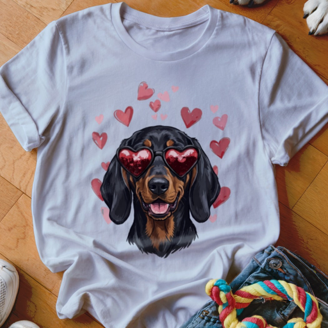 A white t-shirt featuring a graphic of a black and tan dachshund wearing heart-shaped sunglasses surrounded by pink hearts.