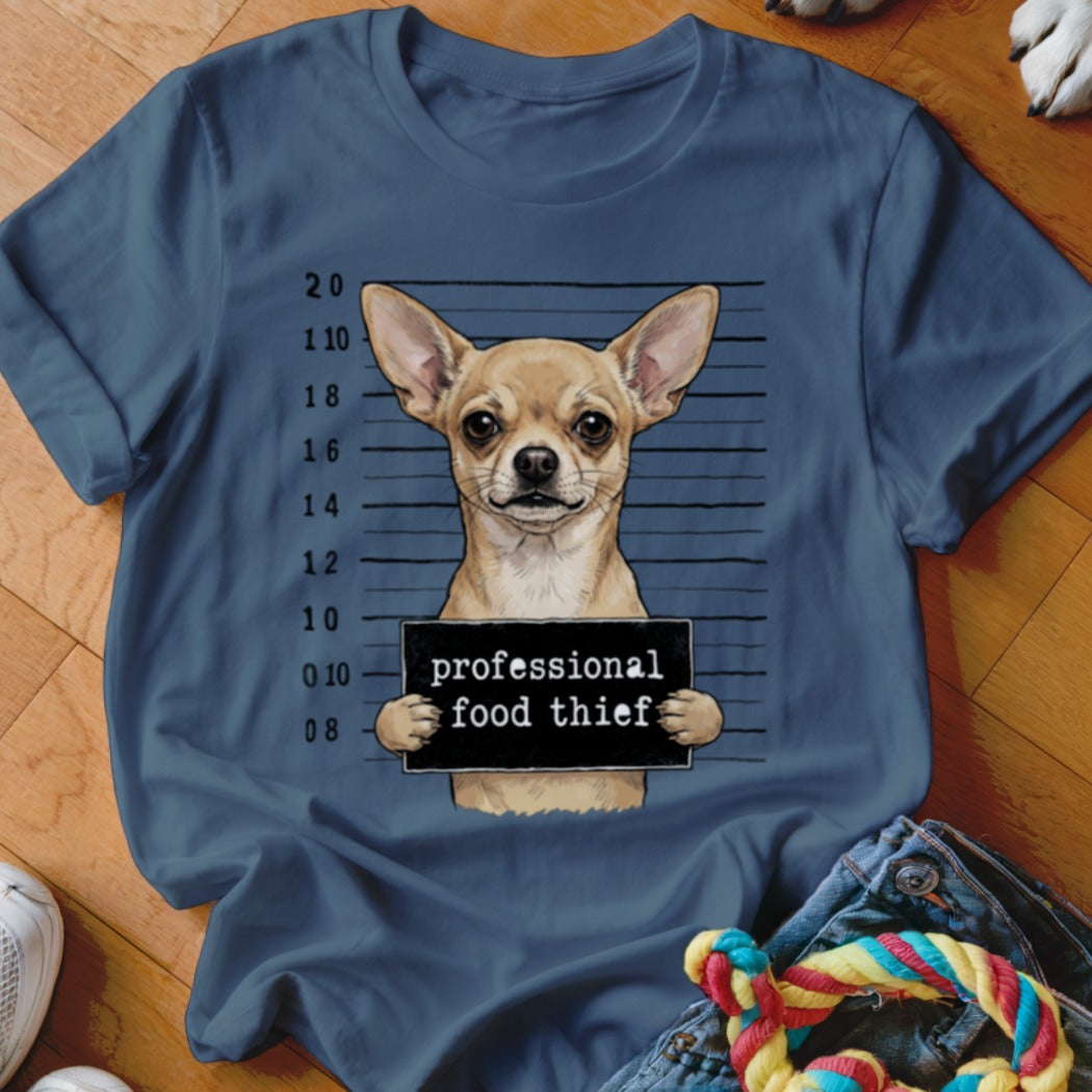 Chihuahua in mugshot holding a sign that says "professional food thief".