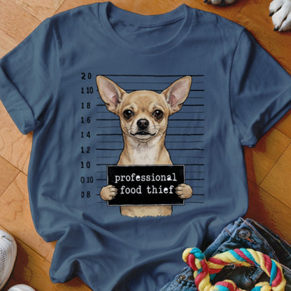 Chihuahua in mugshot holding a sign that says "professional food thief".