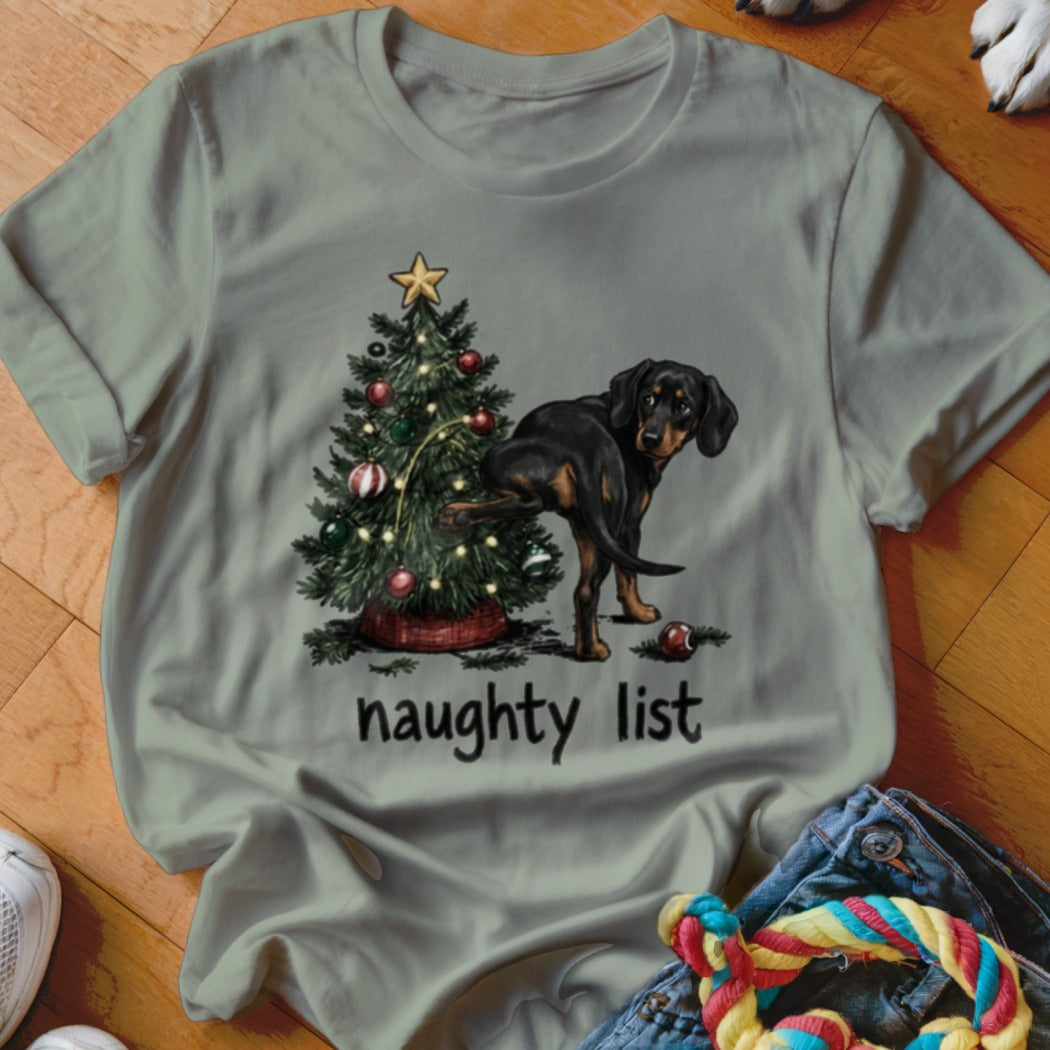 Black and tan dog peeing on Christmas tree with text "naughty list".