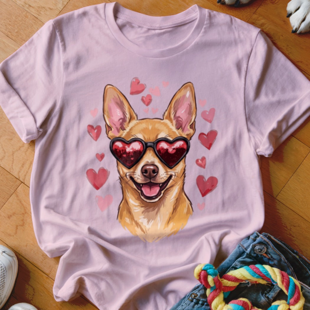 Light pink t-shirt featuring a graphic of a smiling tan dog wearing heart-shaped sunglasses, surrounded by pink hearts.
