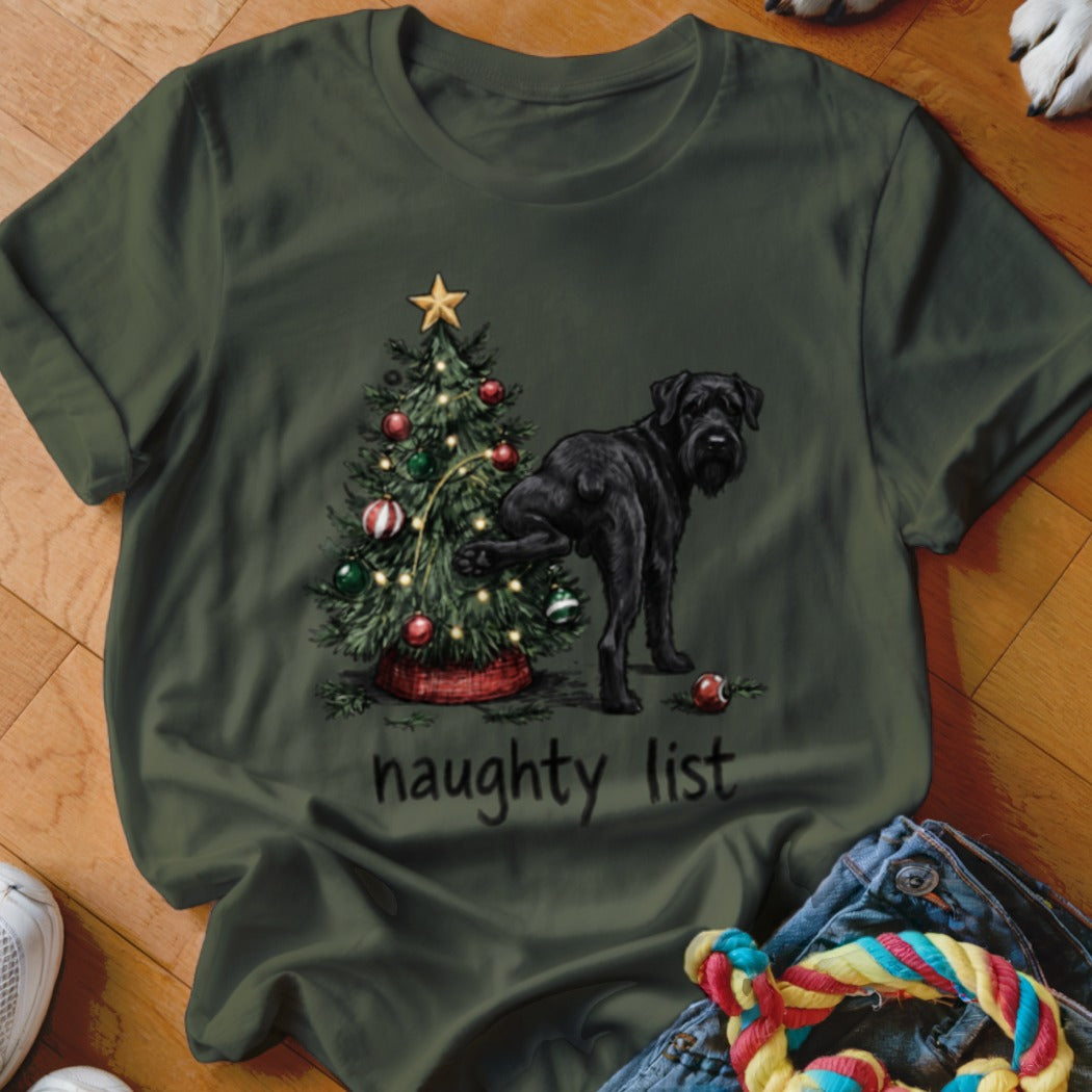 Black dog near a decorated Christmas tree with text "naughty list" on shirt.