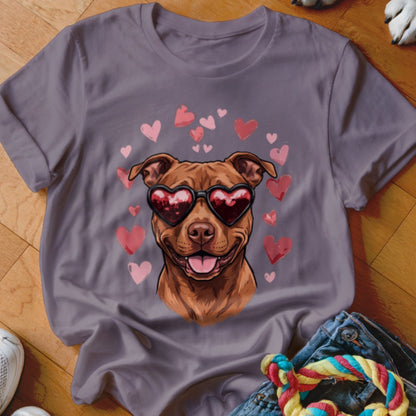 A purple t-shirt featuring a graphic of a brown dog wearing heart-shaped sunglasses surrounded by floating pink hearts.