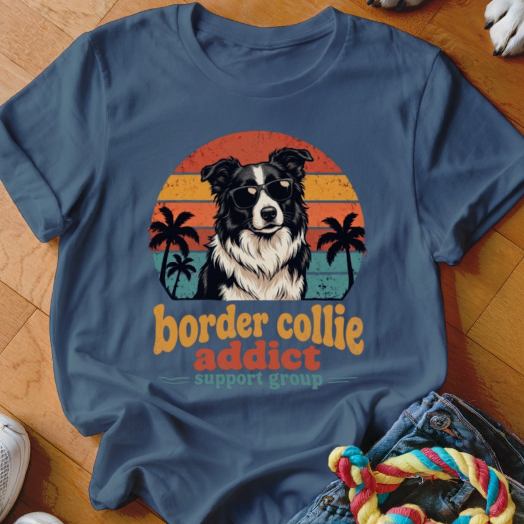 Blue t-shirt featuring a retro sunset graphic of a Border Collie wearing sunglasses and palm trees.