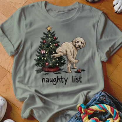 Light-colored dog lifting leg on a Christmas tree with "naughty list" text.