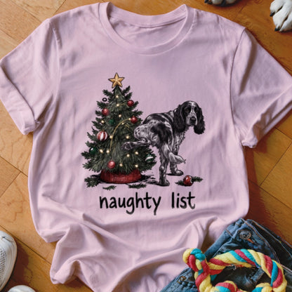 Pink t-shirt with a Christmas tree and a dog standing next to it, with text "naughty list".