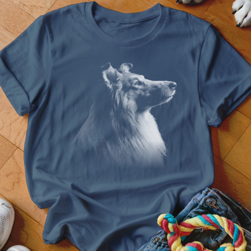 Collie dog portrait graphic on a navy blue t-shirt, shown with jeans and a toy.