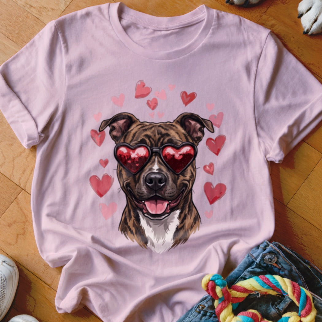 A light pink t-shirt featuring a graphic of a brindle dog wearing heart-shaped sunglasses surrounded by pink hearts.