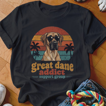 Black t-shirt featuring a retro graphic of a Great Dane in sunglasses with palm trees and sunset stripes.