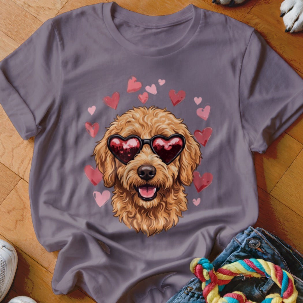 A grey t-shirt featuring a graphic of a golden doodle wearing heart-shaped sunglasses surrounded by pink hearts.