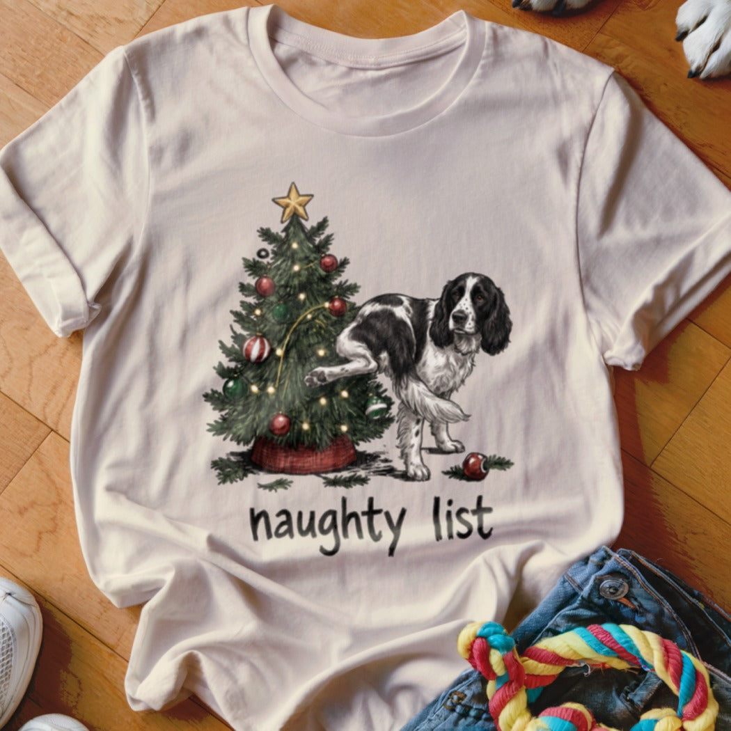 English Springer Spaniel next to a Christmas tree with the text "naughty list".