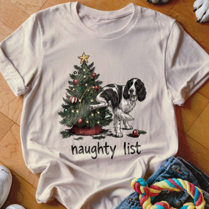 English Springer Spaniel next to a Christmas tree with the text "naughty list".