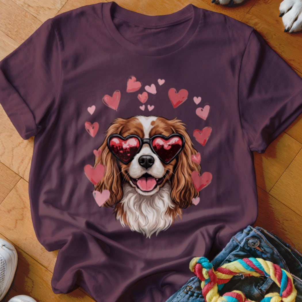 Maroon t-shirt featuring a Cavalier King Charles Spaniel wearing heart-shaped sunglasses surrounded by floating pink hearts.
