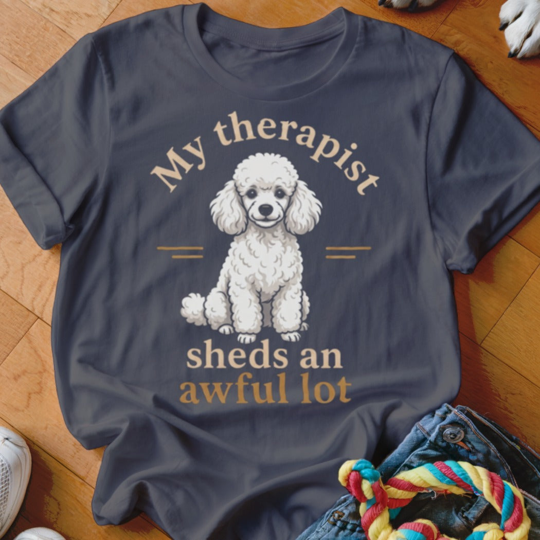 Dark t-shirt with a white poodle graphic and text "My therapist sheds an awful lot".