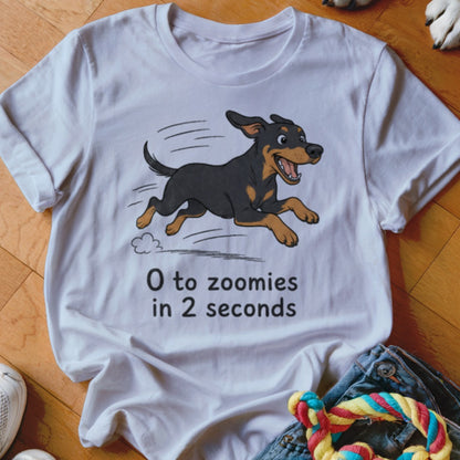 White t-shirt with black and tan dog illustration and text "0 to zoomies in 2 seconds".