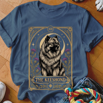 A navy blue t-shirt printed with a tarot card graphic featuring a Keeshond dog.