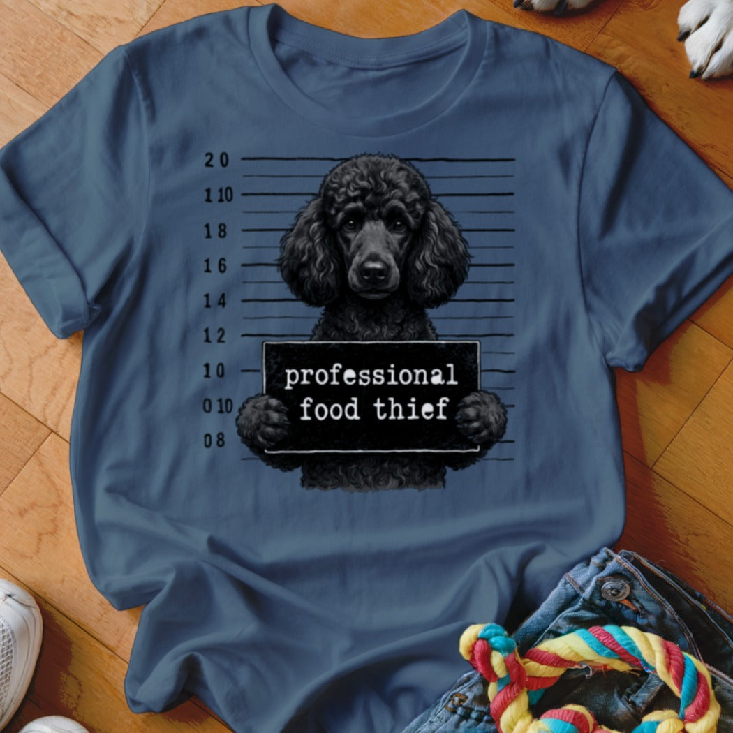 Black poodle mugshot with "professional food thief" sign.
