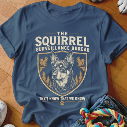 Blue t-shirt featuring a graphic of a German Shepherd inside a crest with squirrels and the text THE SQUIRREL SURVEILLANCE BUREAU.