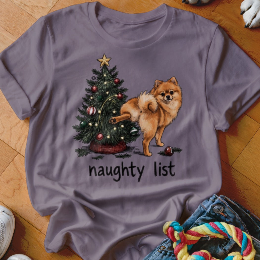 Pomeranian dog lifting leg on Christmas tree with text "naughty list"