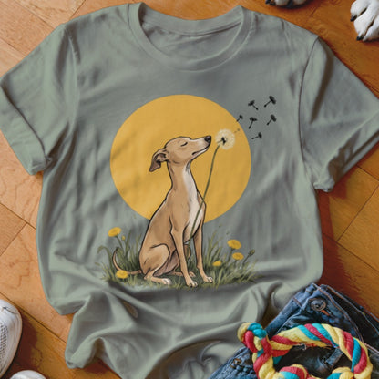A sage green t-shirt featuring a graphic of an Italian Greyhound blowing dandelion seeds in front of a yellow sun.