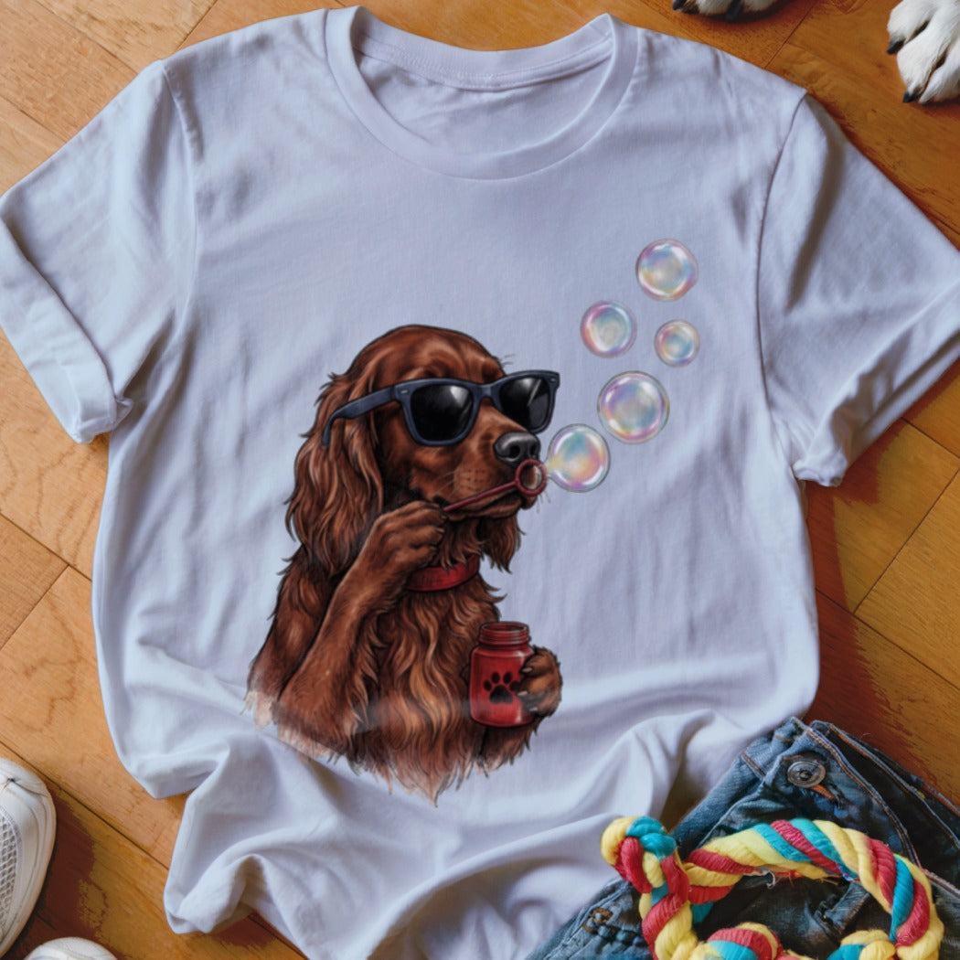 A white t-shirt featuring an illustration of a brown dog wearing sunglasses and blowing bubbles.