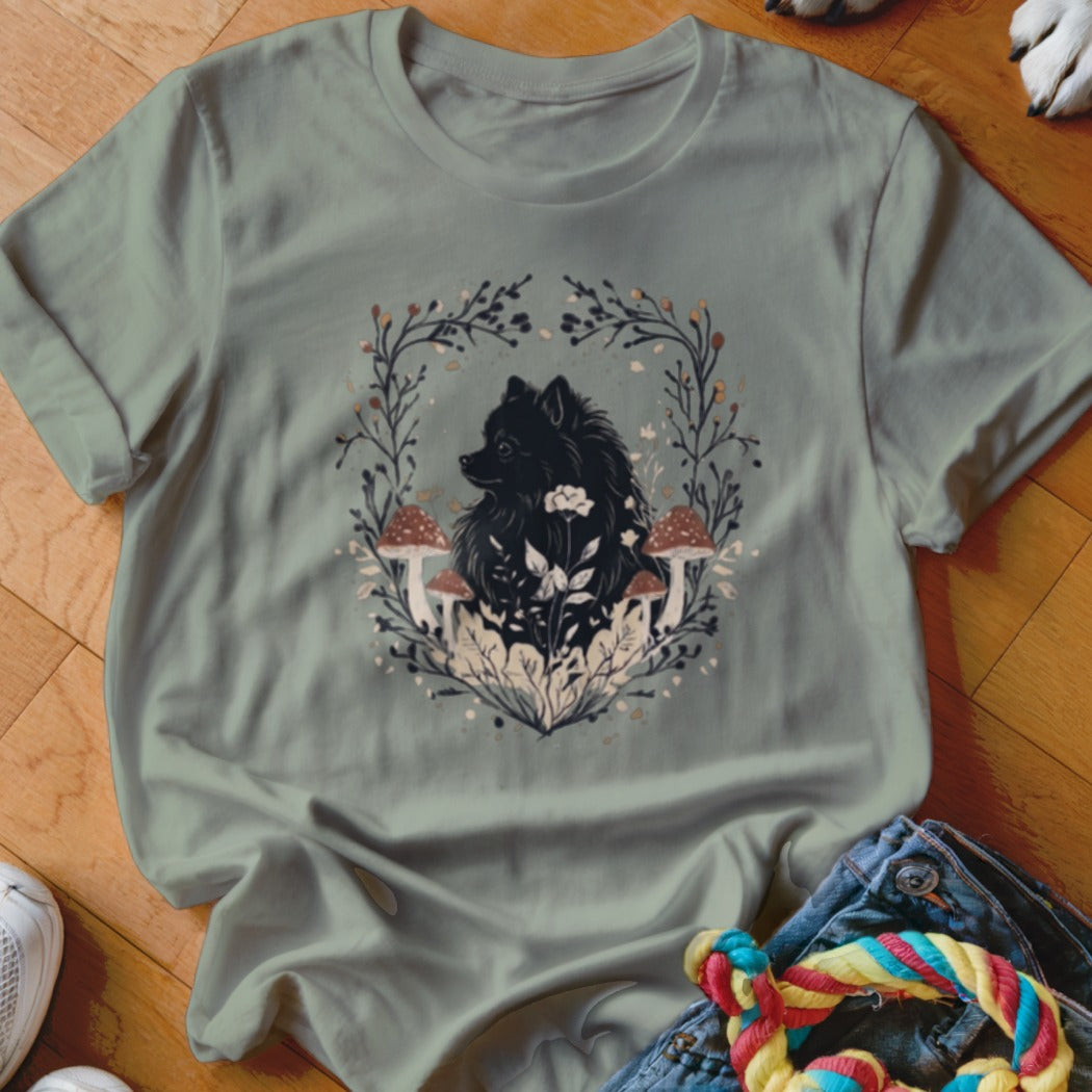 Sage green crewneck t-shirt featuring a black Pomeranian surrounded by botanical floral and mushroom graphics.