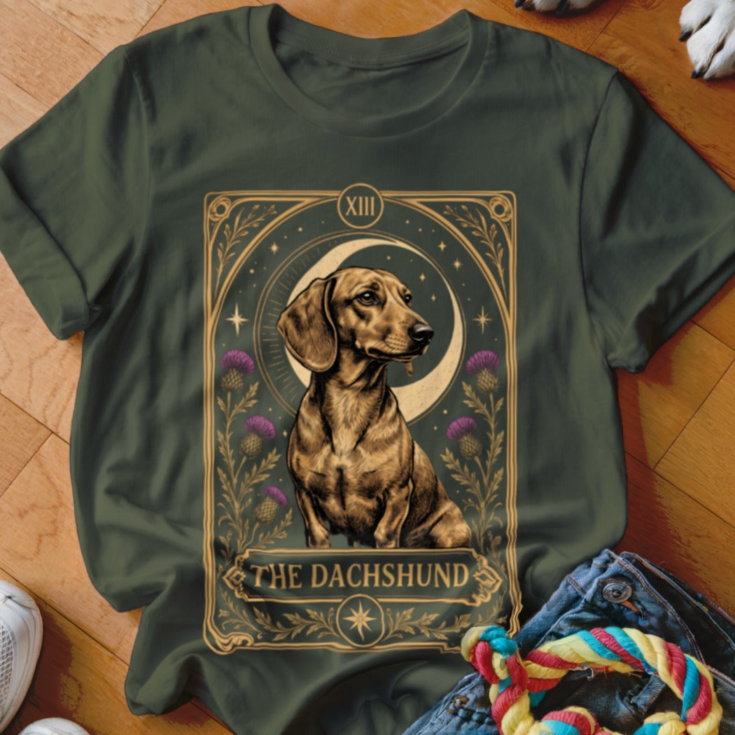 Dark green t-shirt featuring a tarot card graphic of a dachshund with a moon and thistle flowers.