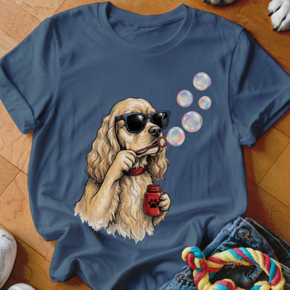 Dark blue t-shirt featuring a graphic of a Cocker Spaniel wearing sunglasses and blowing bubbles.