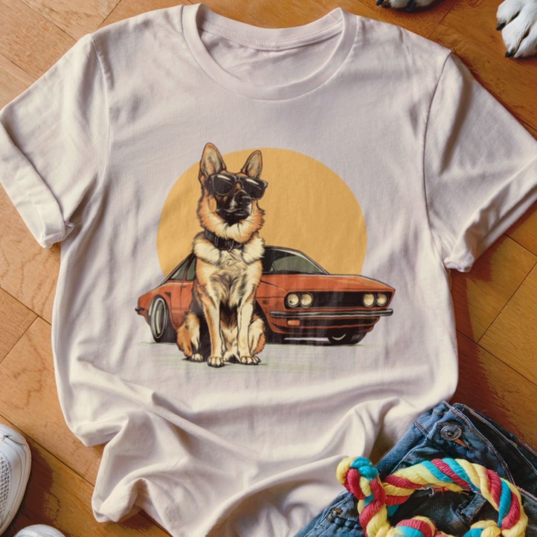 German Shepherd in sunglasses sits by a vintage car with a yellow circle behind.