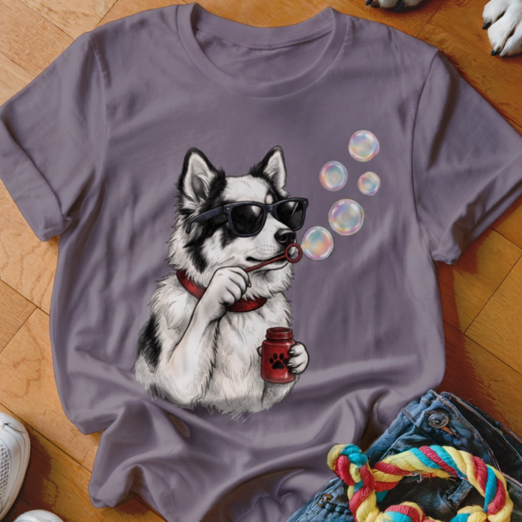 A grey crewneck t-shirt featuring an illustration of a black and white dog wearing sunglasses and blowing bubbles.