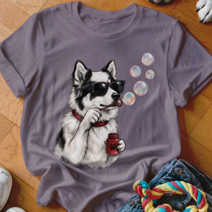 A grey crewneck t-shirt featuring an illustration of a black and white dog wearing sunglasses and blowing bubbles.