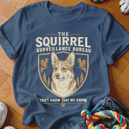 Blue t-shirt featuring a corgi crest graphic with text reading The Squirrel Surveillance Bureau.