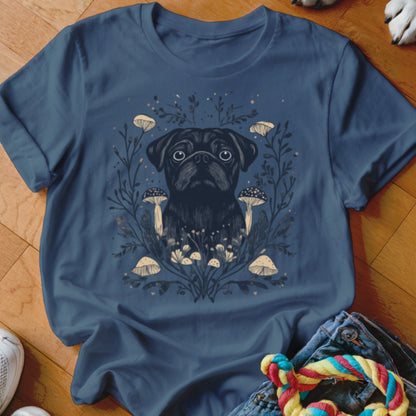 Dark pug surrounded by mushrooms and foliage on a navy t-shirt.