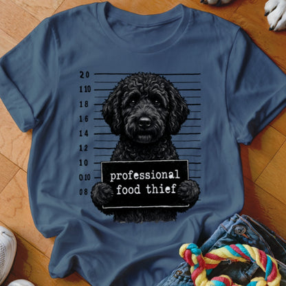 Black doodle dog mugshot with sign reading "professional food thief".