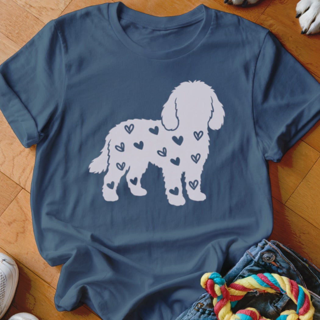 White dog silhouette filled with dark blue hearts on a navy t-shirt.