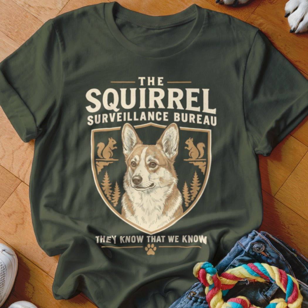 Dark green t-shirt with a crest graphic featuring a corgi and the text The Squirrel Surveillance Bureau.